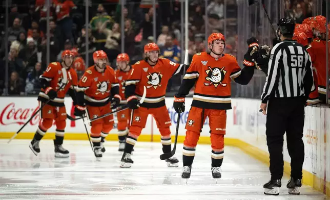 Anaheim Ducks defenseman Jackson Lacombe (2) celebrates his goal with the bench during the second period of an NHL hockey game against the Vancouver Canucks, Wednesday, Nov. 26, 2025, in Anaheim, Calif. (AP Photo/Kyusung Gong)