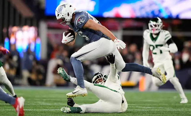 New England Patriots tight end Hunter Henry jumps over New York Jets safety Isaiah Oliver during the first half of an NFL football game, Thursday, Nov. 13, 2025, in Foxborough, Mass. (AP Photo/Robert F. Bukaty)