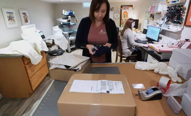 Fran Poirier, left, and her sister, Sue Bacarro, right, fill orders at their Etsy shop, Digi Wildflowers, Thursday, Oct. 30, 2025, in Windsor, Ontario, Canada. (AP Photo/Paul Sancya)
