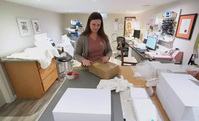 Sue Bacarro packages an order for shipping at her Etsy shop, Digi Wildflowers, Thursday, Oct. 30, 2025, in Windsor, Ontario, Canada. (AP Photo/Paul Sancya)