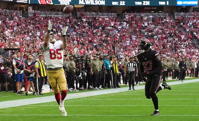 San Francisco 49ers tight end George Kittle (85) catches a touchdown pass in front of Arizona Cardinals linebacker Akeem Davis-Gaither (27) during the first half of an NFL football game in Glendale, Ariz., Sunday, Nov. 16, 2025. (AP Photo/Ross D. Franklin)