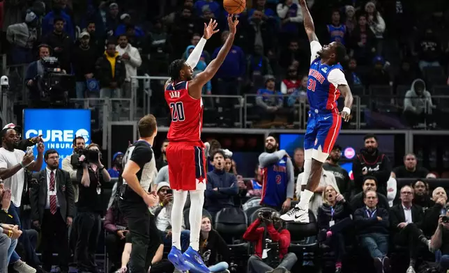 Washington Wizards center Alex Sarr, left, shoots against Detroit Pistons guard Javonte Green during overtime in an NBA basketball game Monday, Nov. 10, 2025, in Detroit. (AP Photo/Ryan Sun)