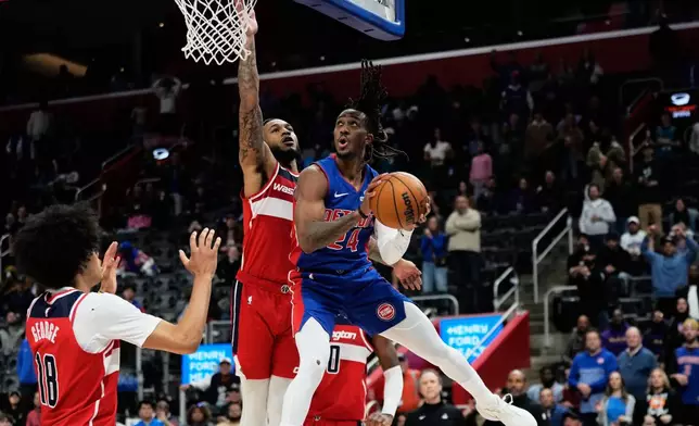 Detroit Pistons guard Daniss Jenkins, right, shoots against Washington Wizards forward Kyshawn George, left, and forward Cam Whitmore during overtime in an NBA basketball game Monday, Nov. 10, 2025, in Detroit. (AP Photo/Ryan Sun)