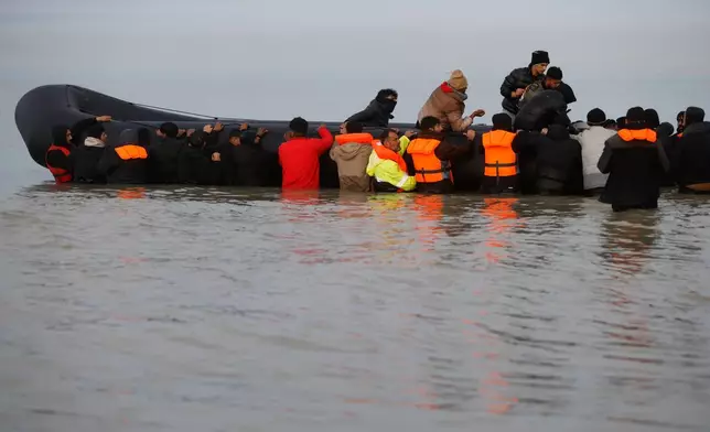 Migrants return to the beach after a failed attempt to reach Britain, Thursday, Nov. 6, 2025 in Gravelines, northern France. (AP Photo/Jean-Francois Badias)