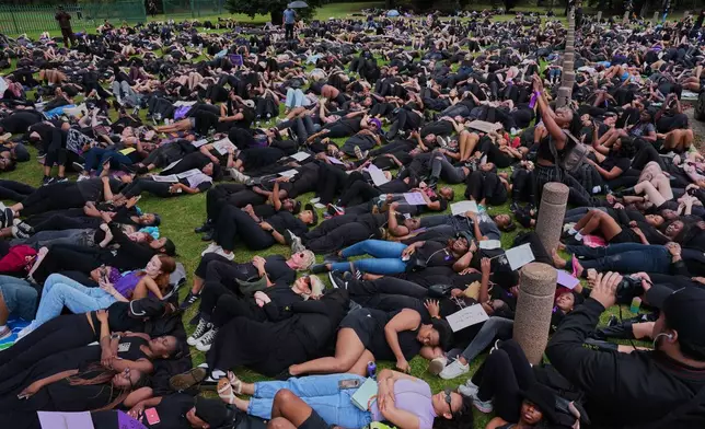 Participants lie on the ground during a gender-based violence protest at the forecourt of the botanical gardens in Johannesburg, South Africa, Friday, Nov. 21, 2025. (Misper Apawu)