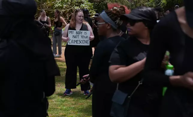 A participant holds a sign reading "My body is not your crime scene" during a gender-based violence protest at the forecourt of the botanical gardens in Johannesburg, South Africa, Friday, Nov. 21, 2025. (Misper Apawu)