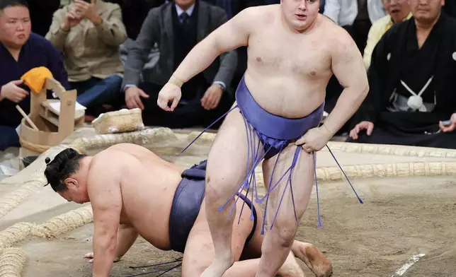 Ukrainian Aonishiki, right, reacts after defeating yokozuna Hoshoryu to win the Kyushu Grand Sumo Tournament in Fukuoka, western Japan, Sunday, Nov. 23, 2025. (Kyodo News via AP)