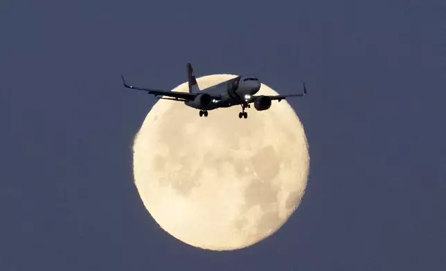 FILE - A TAP Air Portugal Airbus A320 is silhouetted against the setting moon while approaching for landing in Lisbon, Portugal, June 23, 2024. (AP Photo/Armando Franca, File)