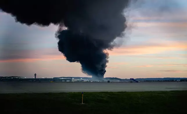 A plume of smoke rises from the site of a UPS cargo plane crash at Louisville Muhammad Ali International Airport on Tuesday, Nov. 4, 2025, in Louisville, Ky. (AP Photo/Jon Cherry)