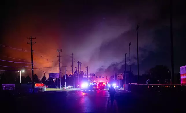 An employee walks to his workplace, the location of the reported crash, after a UPS cargo plane crashed and exploded while taking off at Louisville Muhammad Ali International Airport, Tuesday, Nov. 4, 2025, in Louisville, Ky. (AP Photo/Jon Cherry)