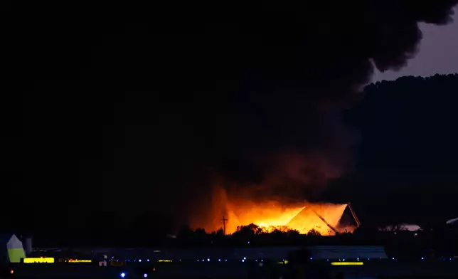 A plume of smoke rises from the site of a UPS cargo plane crash at Louisville Muhammad Ali International Airport on Tuesday, Nov. 4, 2025, in Louisville, Ky. (AP Photo/Jon Cherry)