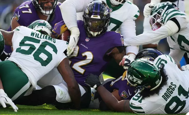 Baltimore Ravens running back Derrick Henry (22) is defended by New York Jets linebacker Quincy Williams (56) and defensive tackle Jowon Briggs (91) during the first half of an NFL football game, Sunday, Nov. 23, 2025, in Baltimore. (AP Photo/Stephanie Scarbrough)