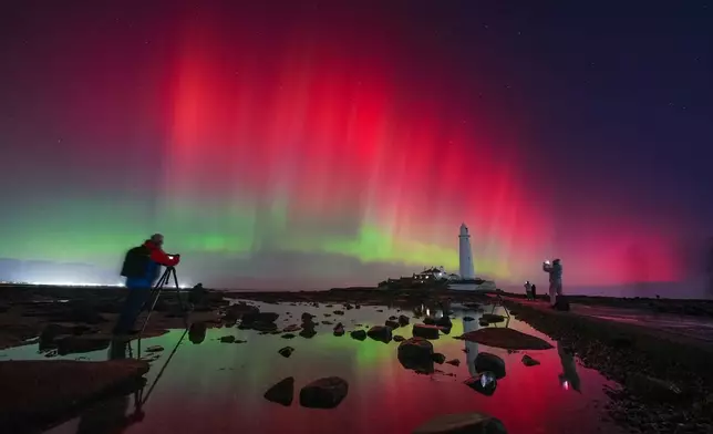 The aurora borealis, also known as the northern lights, glow in the sky over St Mary's Lighthouse in Whitley Bay on the North East coast, England, Wednesday Nov. 12, 2025. (Owen Humphreys/PA via AP)