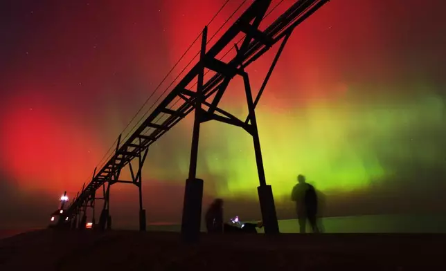 FILE - An aurora borealis, also known as the northern lights, lights up the night sky off Lake Michigan and the St. Joseph Lighthouse, Oct. 10, 2024, in St. Joseph, Mich. (Don Campbell/The Herald-Palladium via AP, File)