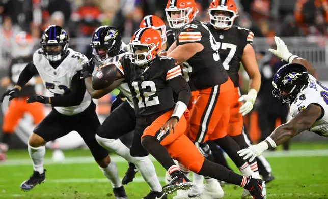 Cleveland Browns quarterback Shedeur Sanders (12) runs the ball as Baltimore Ravens defensive tackle Travis Jones, right, attempts to make the stop in the second half of an NFL football game in Cleveland, Sunday, Nov. 16, 2025. (AP Photo/David Richard)