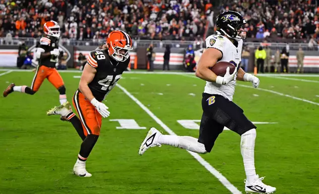 Baltimore Ravens tight end Mark Andrews (89) runs the ball for a touchdown as Cleveland Browns' Carson Schwesinger (49) gives chase in the second half of an NFL football game in Cleveland, Sunday, Nov. 16, 2025. (AP Photo/David Richard)