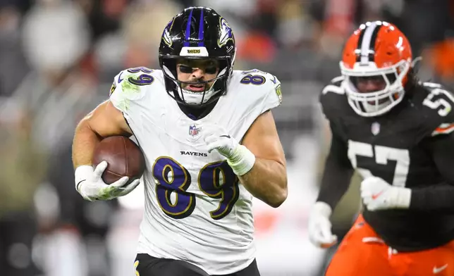 Baltimore Ravens tight end Mark Andrews (89) runs the ball for a touchdown as Cleveland Browns' Isaiah McGuire (57) gives chase in the second half of an NFL football game in Cleveland, Sunday, Nov. 16, 2025. (AP Photo/David Richard)
