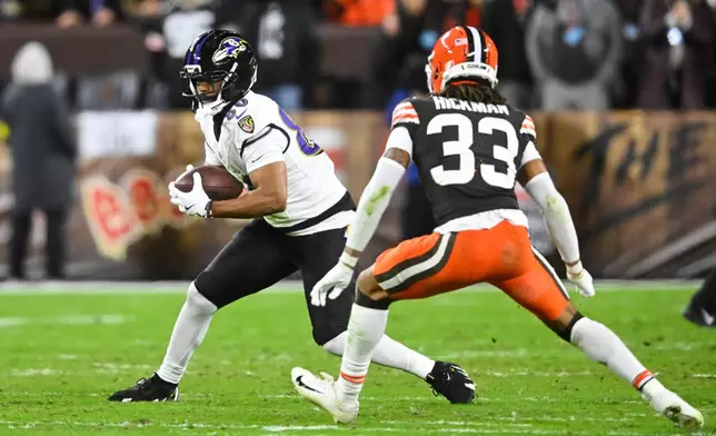Baltimore Ravens tight end Isaiah Likely (80) gains yards after a catch as Cleveland Browns' Ronnie Hickman (33) defends in the second half of an NFL football game in Cleveland, Sunday, Nov. 16, 2025. (AP Photo/David Richard)