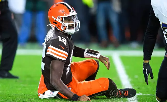 Cleveland Browns quarterback Shedeur Sanders sits on the field watching after throwing an interception in the second half of an NFL football game against the Baltimore Ravens in Cleveland, Sunday, Nov. 16, 2025. (AP Photo/David Richard)