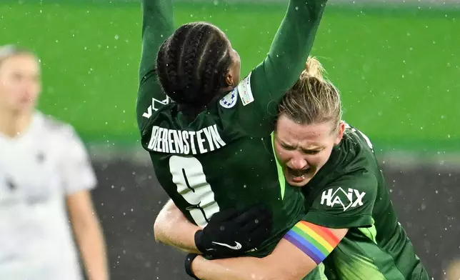 Wolfsburg's Lineth Beerensteyn celebrates scoring with Alexandra Popp, right, during the Women's Champions League soccer match between VfL Wolfsburg and Manchester United in Wolfsburg, Germany, Wednesday Nov. 19, 2025. (Swen Pförtner/dpa via AP)