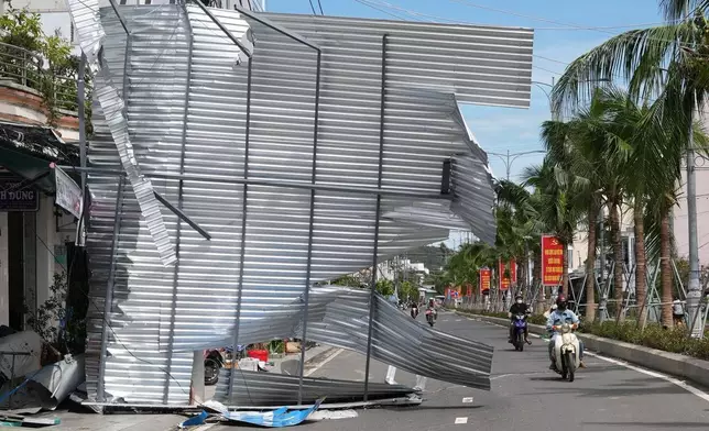 A damaged building blocks a road in Dak Lak, Vietnam on Friday, Nov. 7, 2025 after Typhoon Kalmaegi lashed Vietnam with fierce winds and torrential rains. (AP Photo/Hau Dinh)