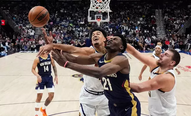 New Orleans Pelicans center Yves Missi (21) battles under the basket between Denver Nuggets forward Spencer Jones, left, and center Nikola Jokic in the second half of an NBA basketball game, Wednesday, Nov. 19, 2025, in New Orleans. (AP Photo/Gerald Herbert)