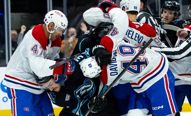 Utah Mammoth left wing Brandon Tanev (13) fights with Montréal Canadiens defenseman Jayden Struble (47), center Jared Davidson (49), and center Joseph Veleno (90) during the second period of an NHL hockey game, Wednesday, Nov. 26, 2025, in Salt Lake City. (AP Photo/Anna Fuder)