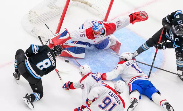 Montréal Canadiens goaltender Jakub Dobes (75) blocks the puck from the shot of Utah Mammoth center Nick Schmaltz (8) during the second period of an NHL hockey game, Wednesday, Nov. 26, 2025, in Salt Lake City. (AP Photo/Tyler Tate)