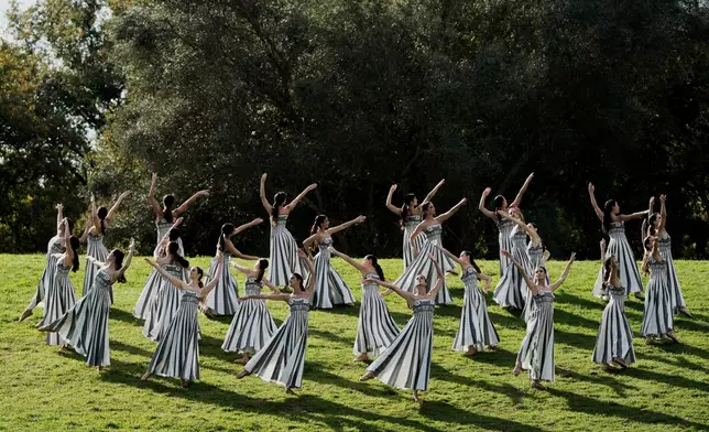 Dancers playing the role of priestesses perform during a rehearsal ahead of the flame lighting for the Milan Cortina 2026 Winter Olympics, at the Ancient Olympia site, Greece, Monday, Nov. 24, 2025. (AP Photo/Thanassis Stavrakis)