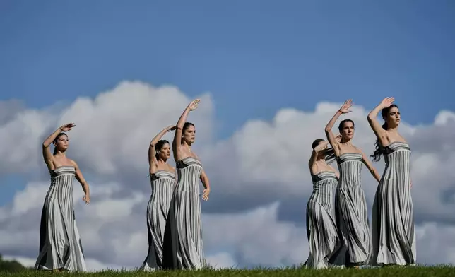 Dancers playing the role of priestesses perform during a rehearsal ahead of the flame lighting for the Milan Cortina 2026 Winter Olympics, at the Ancient Olympia site, Greece, Monday, Nov. 24, 2025. (AP Photo/Petros Giannakouris)