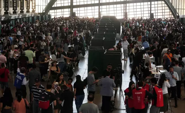Voters stand inside a polling station during general elections in Santiago, Chile, Sunday, Nov. 16, 2025. (AP Photo/Esteban Felix)