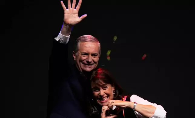 Presidential candidate Jose Antonio Kast of the Republican Party, accompanied by his wife Maria Pia Adriasola, waves to supporters after early results in the general elections in Santiago, Chile, Sunday, Nov. 16, 2025. (AP Photo/Esteban Felix)