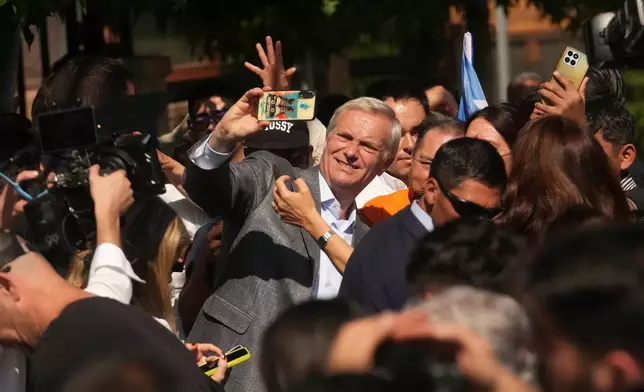 Presidential candidate Jose Antonio Kast of the Republican Party takes a selfie after voting, outside a polling station during general elections in Santiago, Chile, Sunday, Nov. 16, 2025. (AP Photo/Esteban Felix)