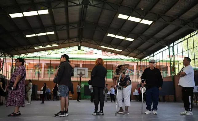 Voters line up at a polling station during general elections in Santiago, Chile, Sunday, Nov. 16, 2025. (AP Photo/Natacha Pisarenko)
