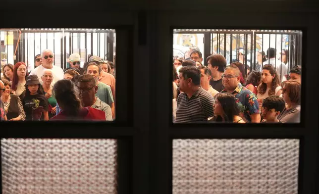 Voters line up at a polling station during general elections in Santiago, Chile, Sunday, Nov. 16, 2025. (AP Photo/Esteban Felix)