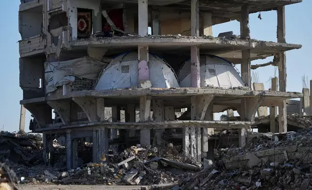 Tents are set up inside a gutted apartment building in Khan Younis, in the southern Gaza Strip, Saturday, Nov. 15, 2025. (AP Photo/Abdel Kareem Hana)