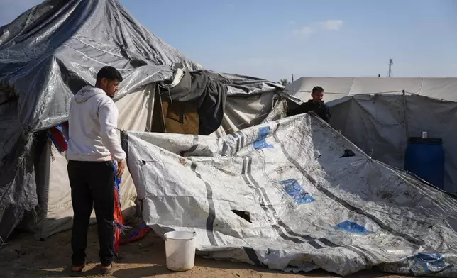 Muhannad Abu Muharib, 27, reinforces his tent after it was damaged by a storm at a temporary camp on the beach in Deir al-Balah, in the central Gaza Strip, Saturday, Nov. 15, 2025. (AP Photo/Abdel Kareem Hana)
