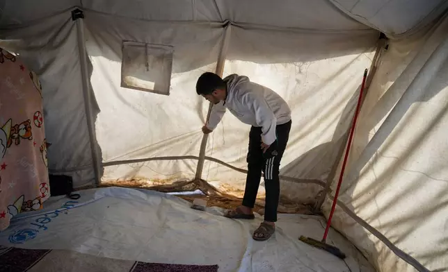 Muhannad Abu Muharib, 27, reinforces his tent after it was damaged by the storm at a temporary camp on the beach in Deir al-Balah, in the central Gaza Strip, Saturday, Nov. 15, 2025.(AP Photo/Abdel Kareem Hana)