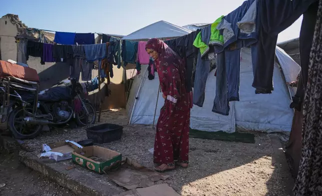Amal Mahmoud, 36, hangs up clothes just outside her tent in a temporary camp on the beach in Deir al-Balah, in the central Gaza Strip, on Saturday, Nov. 15, 2025.(AP Photo/Abdel Kareem Hana)