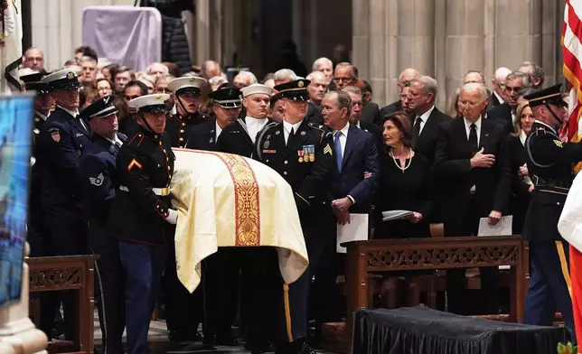 Former Presidents front row from left, George W. Bush with Laura Bush and Joe Biden with Jill Biden, look on as military pall bearers arrive with the casket of former Vice President Dick Cheney at the Washington National Cathedral, Thursday, Nov. 20, 2025 in Washington. (AP Photo/Matt Rourke)