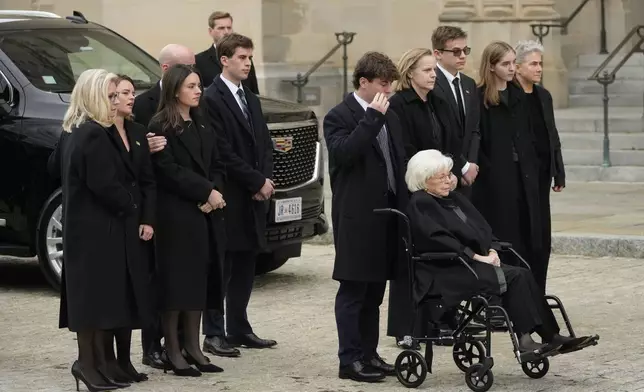 Wife of former Vice President Dick Cheney, Lynne Cheney in wheelchair, along with daughter, former Rep. Liz Cheney, R-Wyo., left, and family preside over the arrival of the casket of former Vice President Dick Cheney at the Washington National Cathedral, Thursday, Nov. 20, 2025, in Washington. (AP Photo/Mark Schiefelbein)