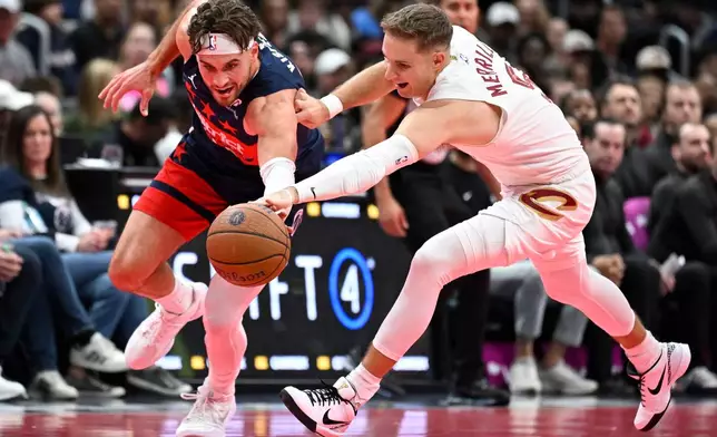 Washington Wizards forward Corey Kispert, left, competes for a loose ball against Cleveland Cavaliers guard Sam Merrill during the first half of an NBA Cup basketball game, Friday, Nov. 7, 2025, in Washington. (AP Photo/John McDonnell)