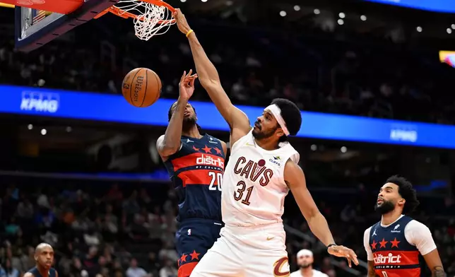 Cleveland Cavaliers center Jarrett Allen (31) dunks over Washington Wizards center Alex Sarr during the first half of an NBA Cup basketball game, Friday, Nov. 7, 2025, in Washington. (AP Photo/John McDonnell)
