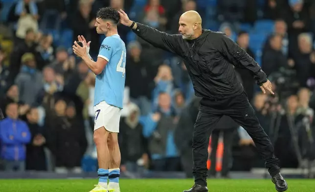Manchester City's head coach Pep Guardiola celebrates with Manchester City's Phil Foden at the end of the English Premier League soccer match between Manchester City and Liverpool in Manchester, England, Sunday, Nov. 9, 2025. (AP Photo/Jon Super)