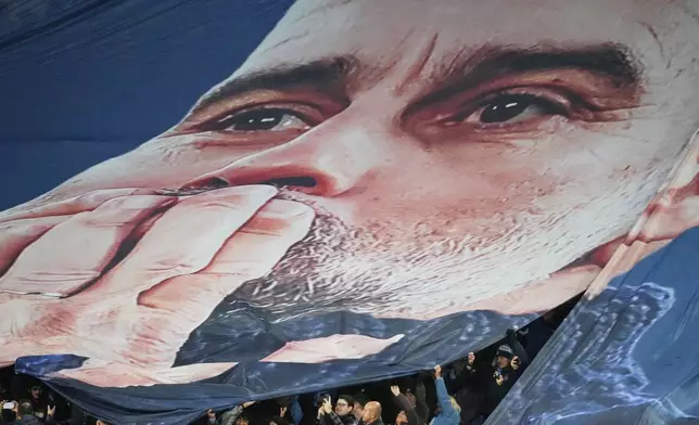 Fans tribute to Pep Guardiola coach of Manchester City 1000th game during the English Premier League soccer match between Manchester City and Liverpool in Manchester, England, Sunday, Nov. 9, 2025. (AP Photo/Jon Super)