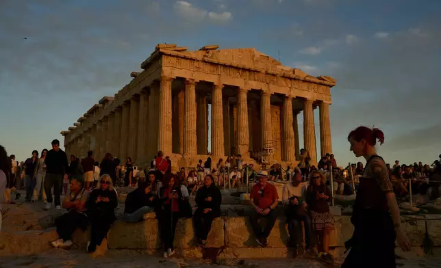 Tourists visit the Acropolis hill and the 5th century B.C. Parthenon temple in Athens, Sunday, Oct. 26, 2025. (AP Photo/Petros Giannakouris)