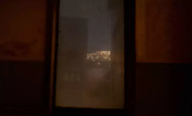 The 5th century B.C. Parthenon temple atop the Acropolis hill is seen through an old, dusty window in Athens, Saturday, Nov. 1 , 2025. (AP Photo/Petros Giannakouris)