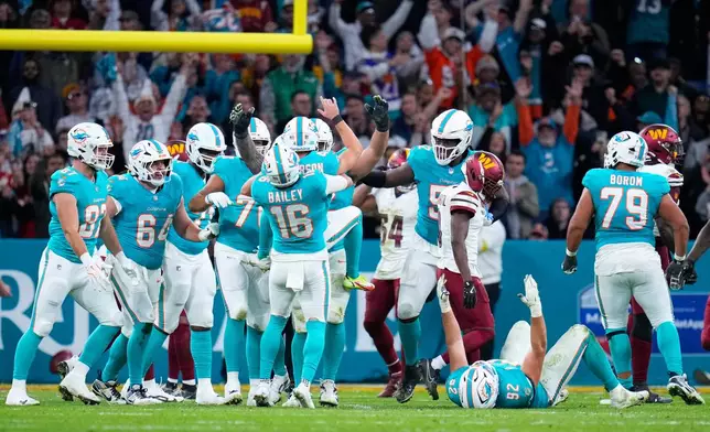 Miami Dolphins players celebrate with place kicker Riley Patterson (47) after his kicked a field goal during overtime to win an NFL football game between the Washington Commanders and the Miami Dolphins in Madrid, Spain, Sunday, Nov. 16, 2025. (AP Photo/Manu Fernandez)