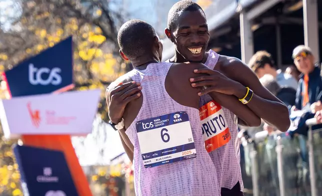 Benson Kipruto and Alexander Mutiso and hug and laugh with each other after a close finish crossing the finish line to win first and second place in the men's elite division of the New York City Marathon, Sunday, Nov. 2, 2025, in New York. (AP Photo/Angelina Katsanis)