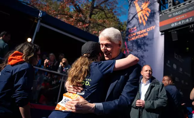 Former President Bill Clinton hugs his daughter, Chelsea Clinton, after Chelsea crossed the finish line of the New York City Marathon, Sunday, Nov. 2, 2025, in New York. (AP Photo/Angelina Katsanis)